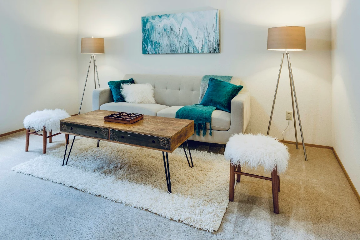 Original living room with sofa, woven chairs and a patterned rug